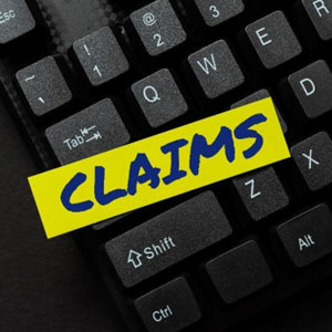 A photo of a keyboard section with a bright yellow sticker reading "claims".